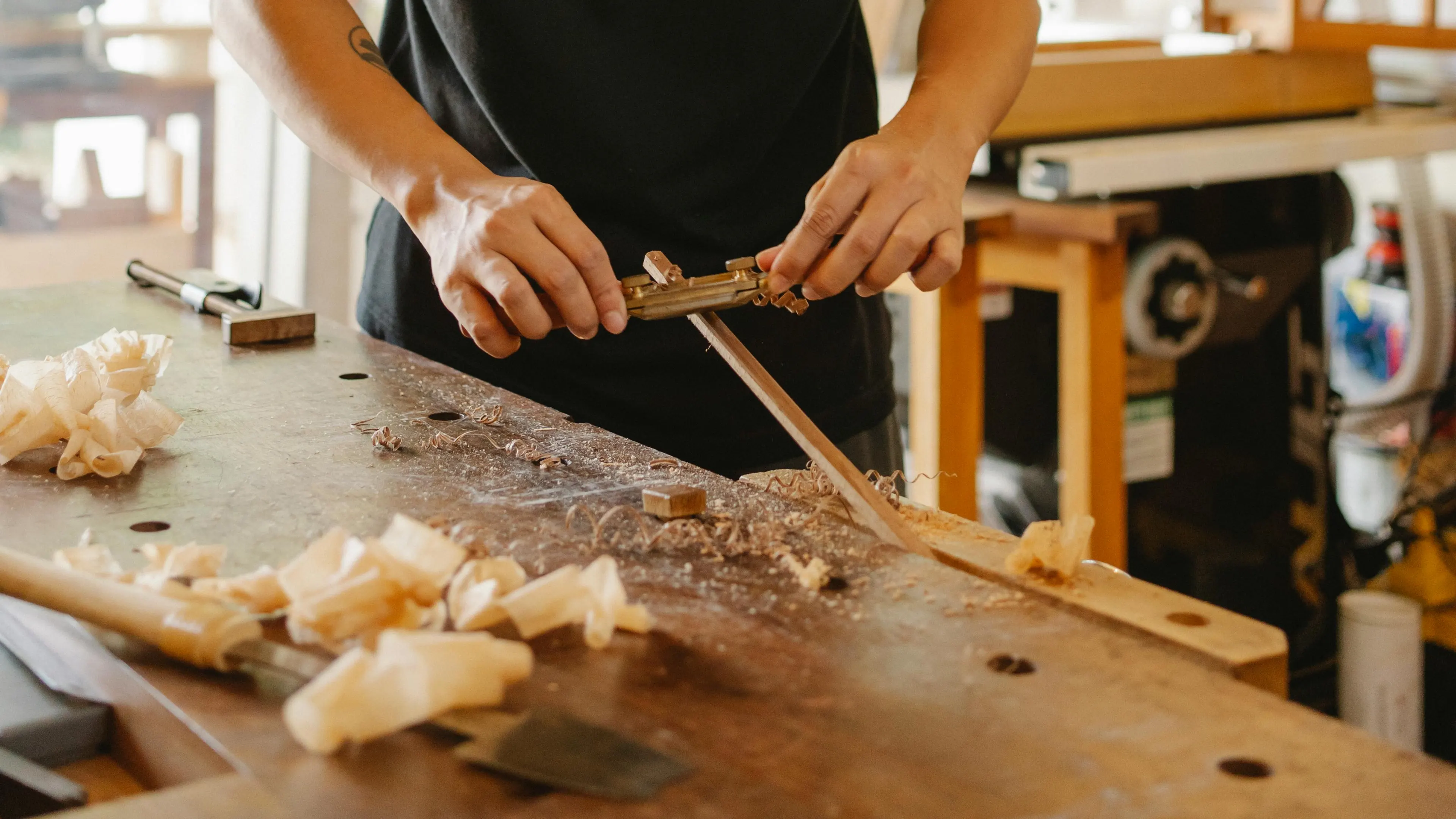 Crop male master shaping wooden stick with spokeshave in workshop. Photo by Ono Kosuki